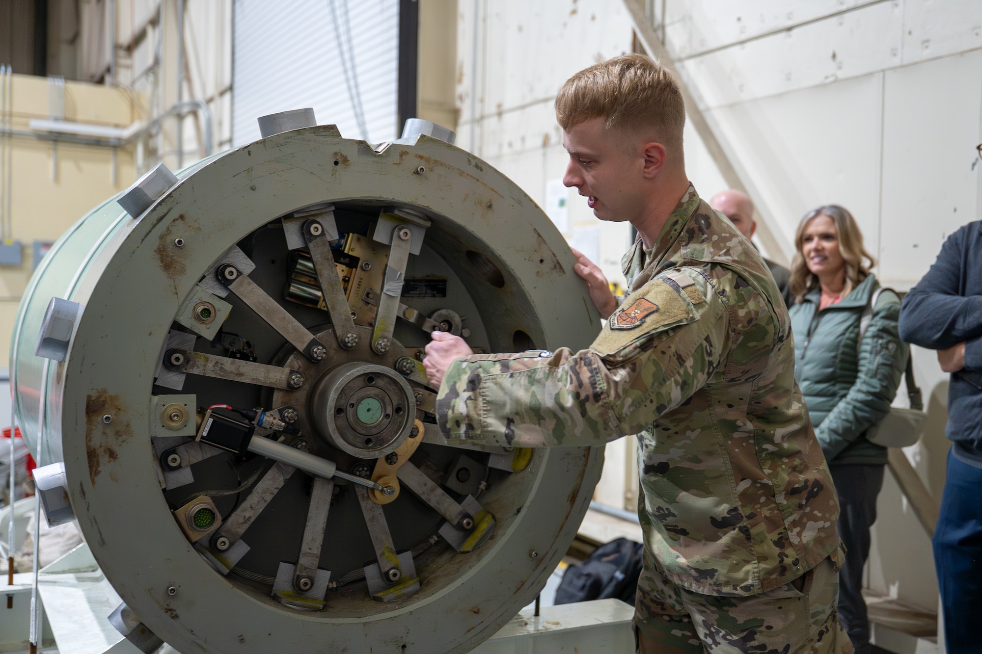 Uniformed personnel shows people a component of an Intercontinental Ballistic Missile system