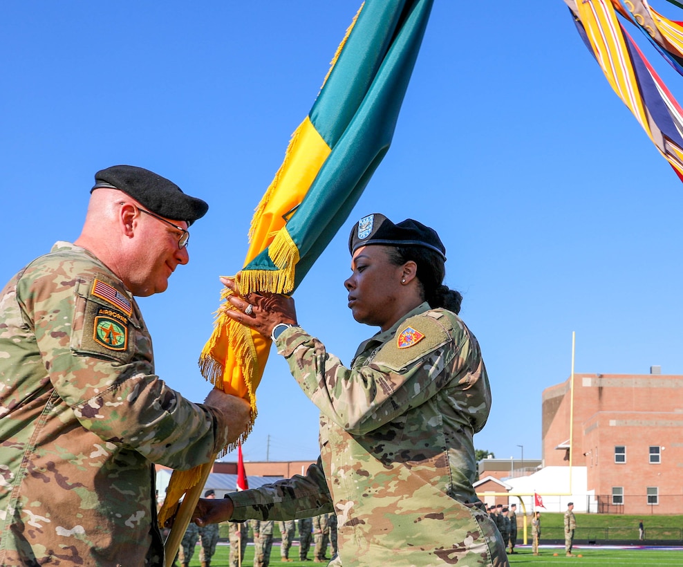 U.S. Army Command Sgt. Maj. Aaron Lester and Col. Brandye Williams exchange the brigade colors for the final time as she relinquishes command to Col. Terry Durham.
