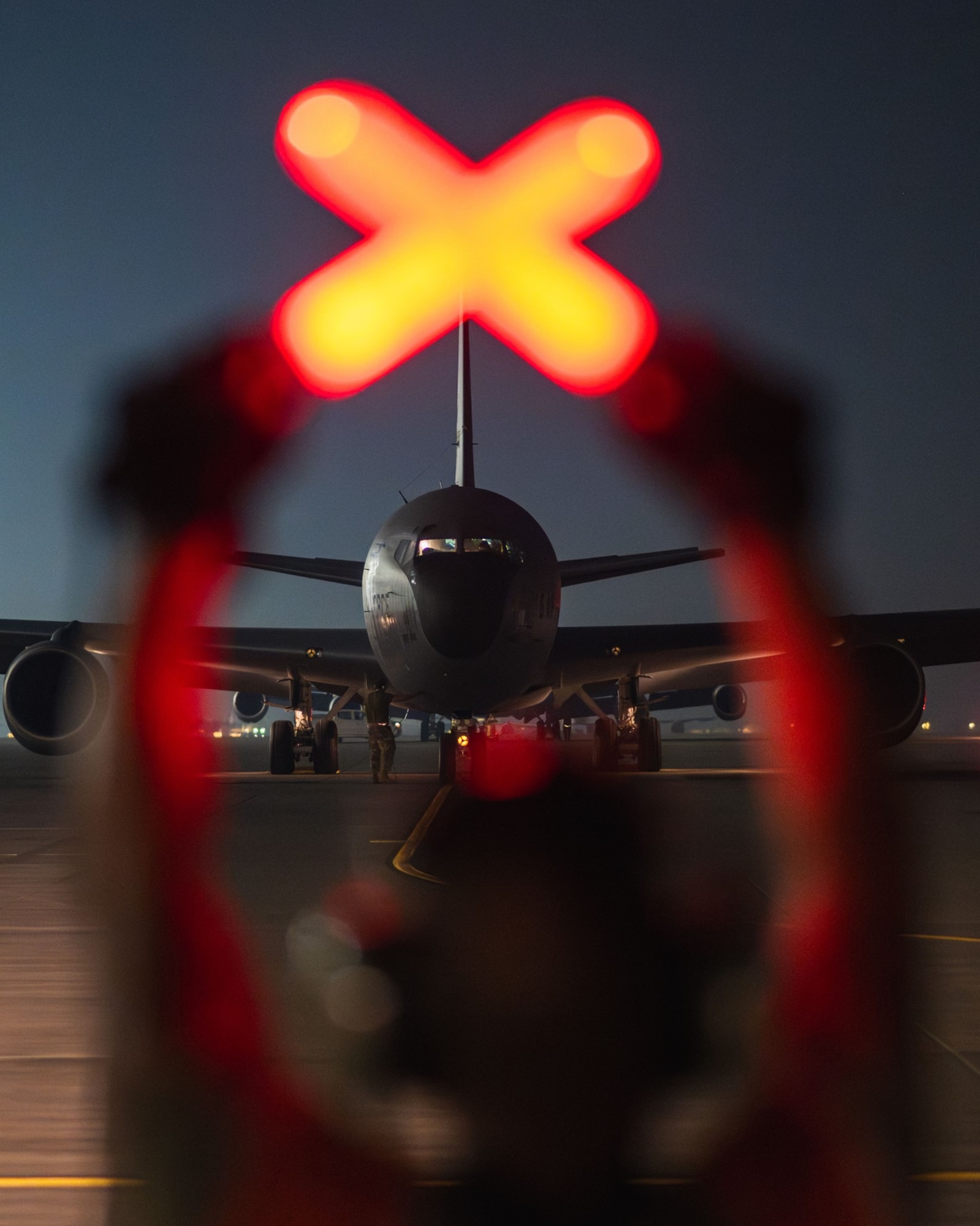 An airman marshals a U.S. Air Force KC-46A assigned to the 305th Air Mobility Wing's Mission Generation Force Element (MGFE) at an undisclosed location as part of the mobilization of the MGFE, which provided crucial air refueling support to U.S. and allied forces during a milestone seven-month contingency operation. The 305 AMW led and partnered with KC-46 and KC-135 air refueling teams and personnel from 16 Active Duty, Reserve and National Guard units, forming the largest Air Force MGFE in theater and the only MGFE to employ two major weapons systems. The MGFE achieved the highest sortie generation rate in theater, flying more than 3,600 KC-46 and KC-135 missions and offloading more than 150 million pounds of fuel to coalition aircraft supporting contingency operations for four combatant commands. (U.S. Air Force courtesy photo)