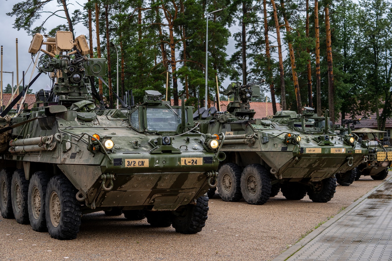 Military armored vehicles are seen parked in a line outdoors.