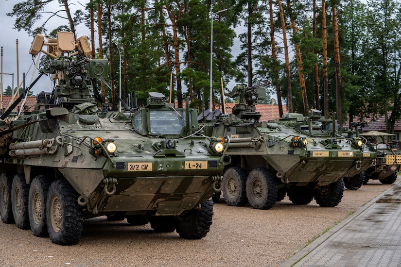 Military armored vehicles are seen parked in a line outdoors.