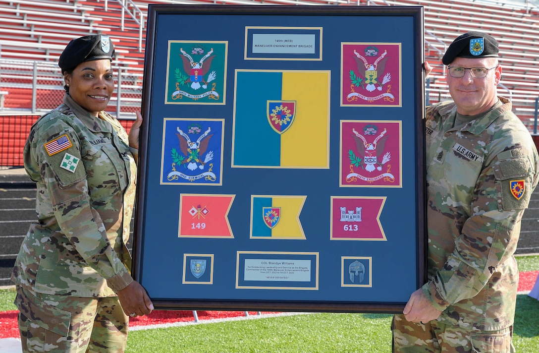 U.S. Army Command Sgt. Maj. Aaron Lester presents Col. Brandye Williams with the colors of the 149th Maneuver Enhancement Brigade and its subordinate units during a change of command ceremony in Richmond, Ky., Oct. 18, 2025.