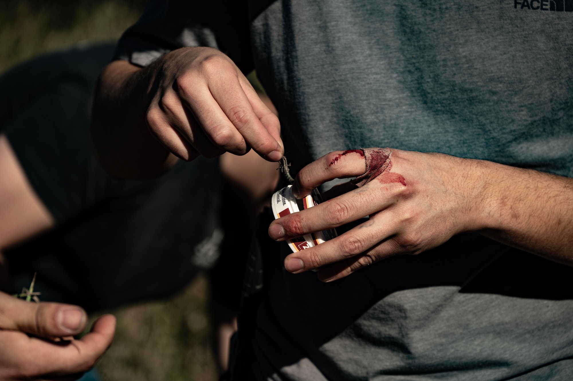 A Team Minot Airman catches a grasshopper during combat survival training at Garrison, North Dakota, Oct. 9, 2025. The course went over basic survival skills including wilderness living, shelter construction, fire building, navigation, first aid, signaling and food and water procurement. (U.S. Air Force photo by Senior Airman Alyssa Bankston)