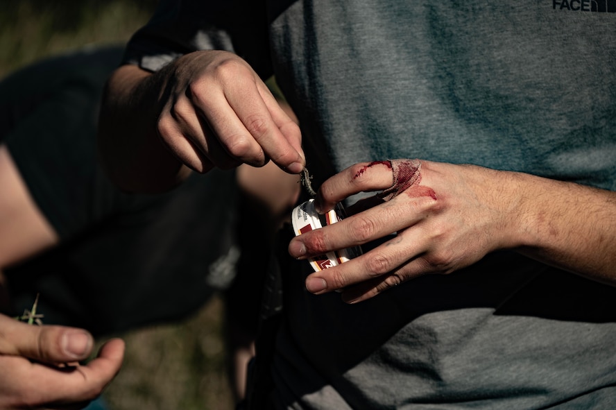 A Team Minot Airman catches a grasshopper during combat survival training at Garrison, North Dakota, Oct. 9, 2025. The course went over basic survival skills including wilderness living, shelter construction, fire building, navigation, first aid, signaling and food and water procurement. (U.S. Air Force photo by Senior Airman Alyssa Bankston)