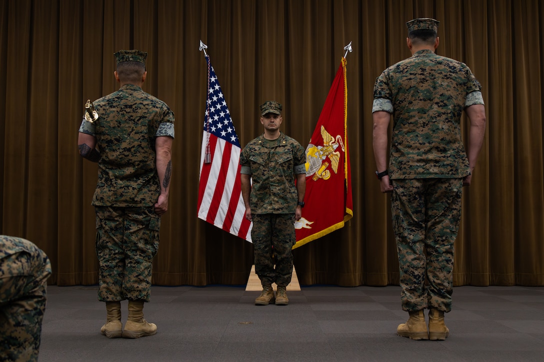 U.S. Marine Corps Maj. Patrick Kolb, center, commanding officer, Sgt. Maj. Sergio Zaratecortina, right, incoming sergeant major, and Sgt. Maj. Gilberto Castilloguzman, outgoing sergeant major, all with Recruiting Station Seattle, participate in a relief and appointment ceremony at Recruiting Station Seattle in Seattle, August 1, 2025. The ceremony serves as the official changeover between sergeants major. (U.S. Marine Corps photo by Sgt. Bruin Largent)