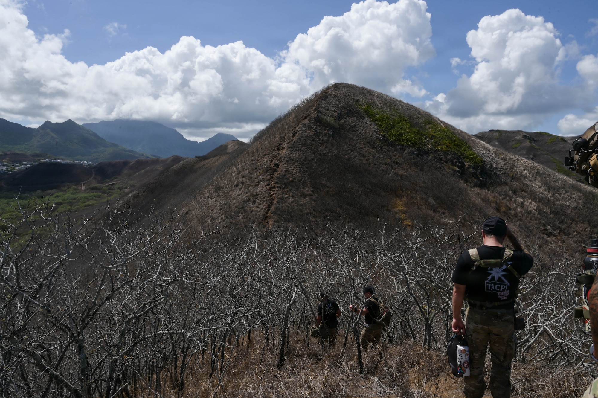 Airmen hike up a peak during the day.