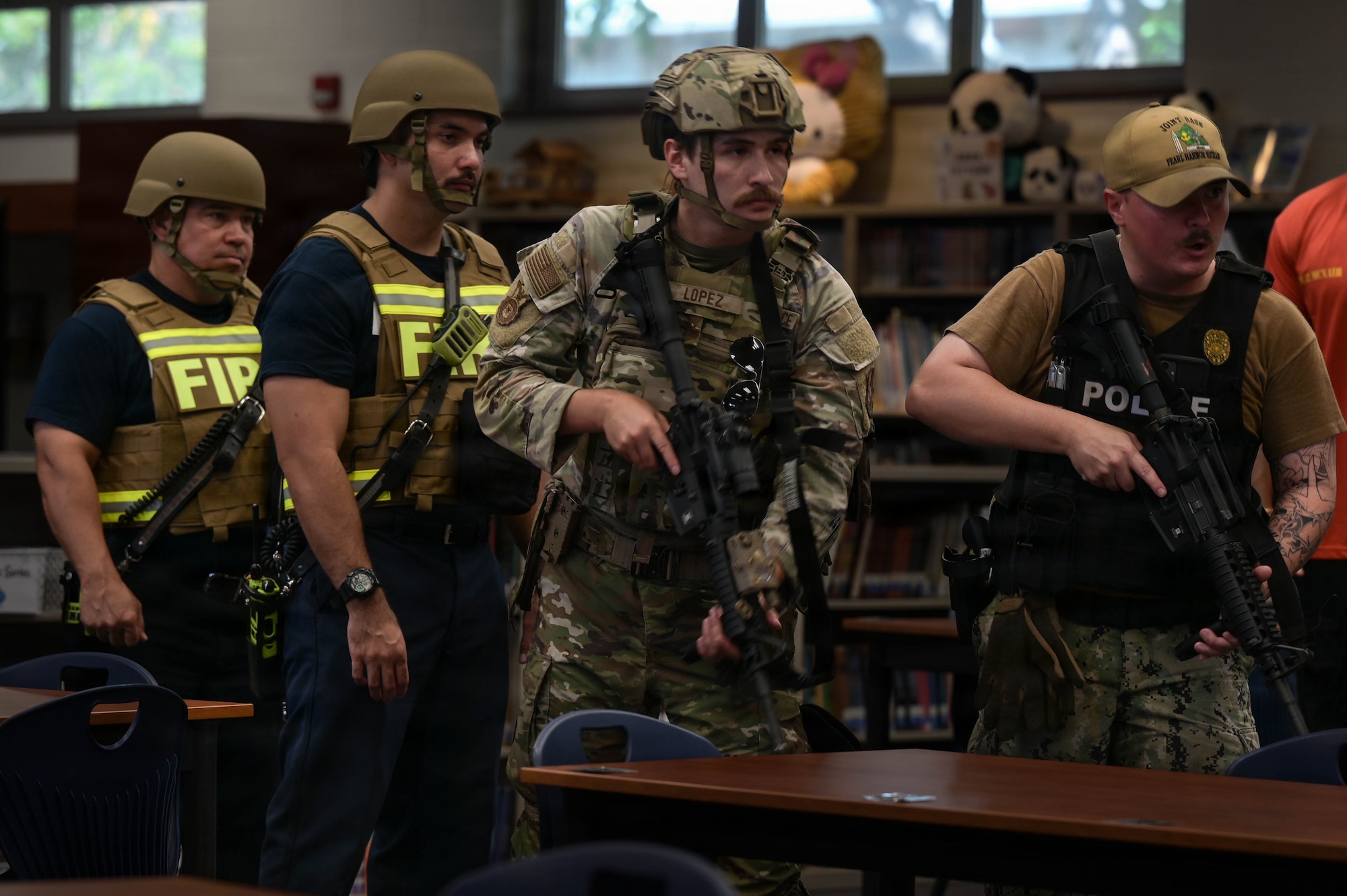 Airmen, Sailors, and firefighters move in formation during an exercise.