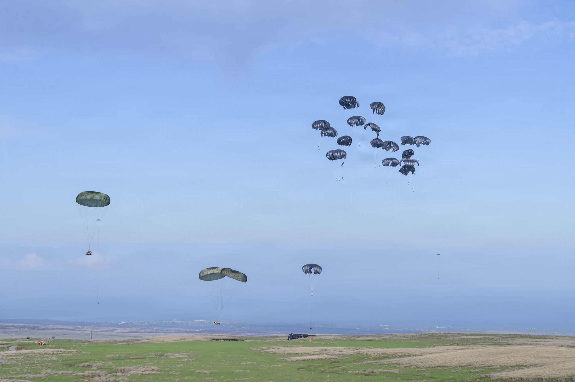 Cargo with parachutes approach land.