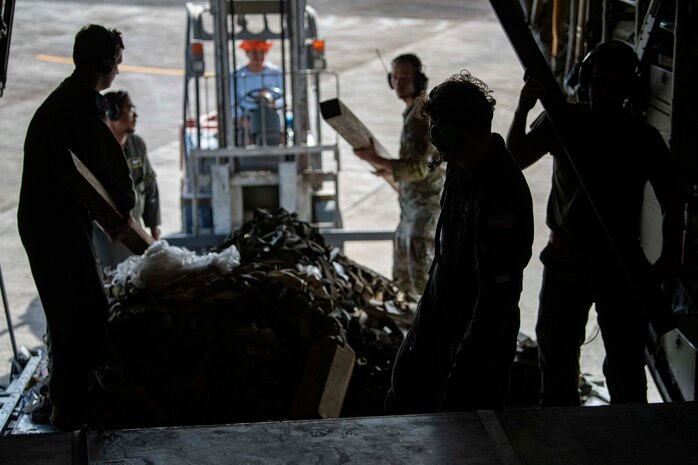 U.S. Air Force Airmen assigned to the 374th Airlift Wing load shoring onto a C-130J Super Hercules assigned to the 36th Airlift Squadron after delivering palletized family food packs during a foreign disaster relief operation.