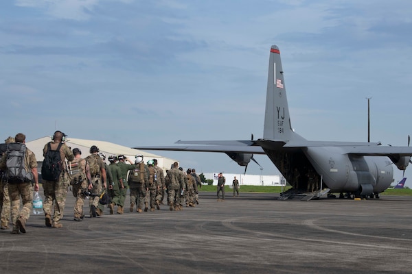 U.S. Air Force Airmen and U.S. Marines prepare to board a C-130J Super Hercules assigned to the 36th Airlift Squadron during a foreign disaster relief operation.