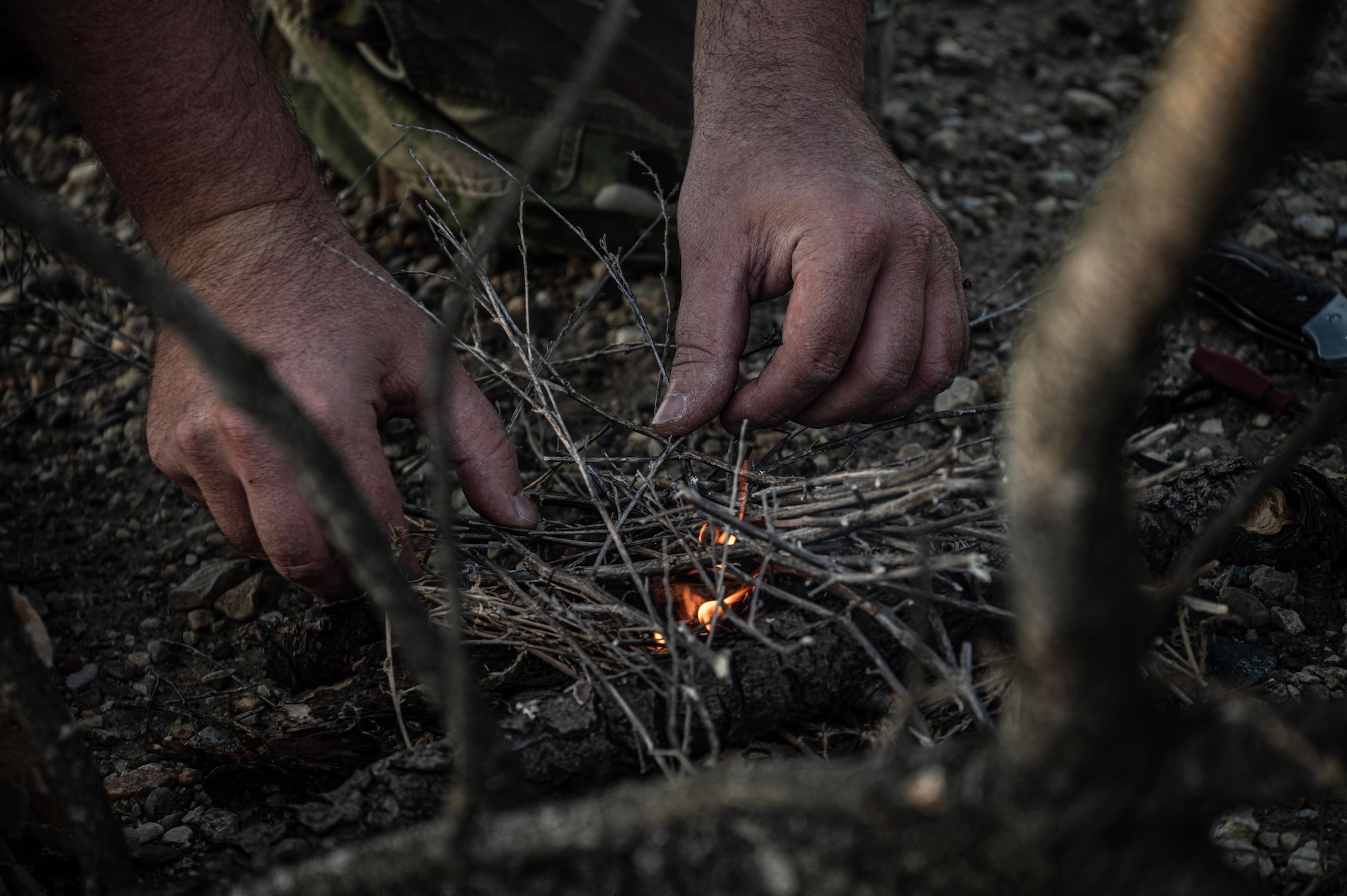 Tech. Sgt. Brett Darby, 5th Operational Support Squadron survival, evade, resistance and escape specialist, shows airmen participating in the combat survival training how to properly start a fire at Garrison, North Dakota, Oct. 9, 2025. Through planning, executing, adapting, and preparing, SERE specialists also help to directly support personnel recovery programs. (U.S. Air Force photo by Senior Airman Alyssa Bankston)