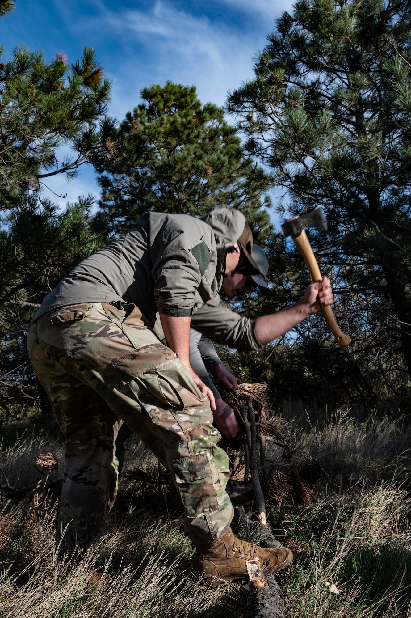 Tech. Sgt. Brett Darby, 5th Operational Support Squadron survival, evade, resistance, escape specialist, shows airmen participating in the combat survival training how to properly build shelter at Garrison, North Dakota, Oct. 9, 2025. In order to better prepare for real-world survival situations, the refresher training helps aircrew hone their skills. (U.S. Air Force photo by Senior Airman Alyssa Bankston)