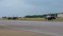 Three Japan Air Self-Defense Force F-15J Eagles assigned to the 204th Fighter Squadron, taxi on the runway for a bilateral training mission with the U.S. Air Force at Naha Air Base, Japan, Nov. 19, 2025. The mission supported ongoing efforts to strengthen bilateral capability and maintain stability across the Indo-Pacific. (U.S. Air Force photo by Airman Nathaniel Jackson)