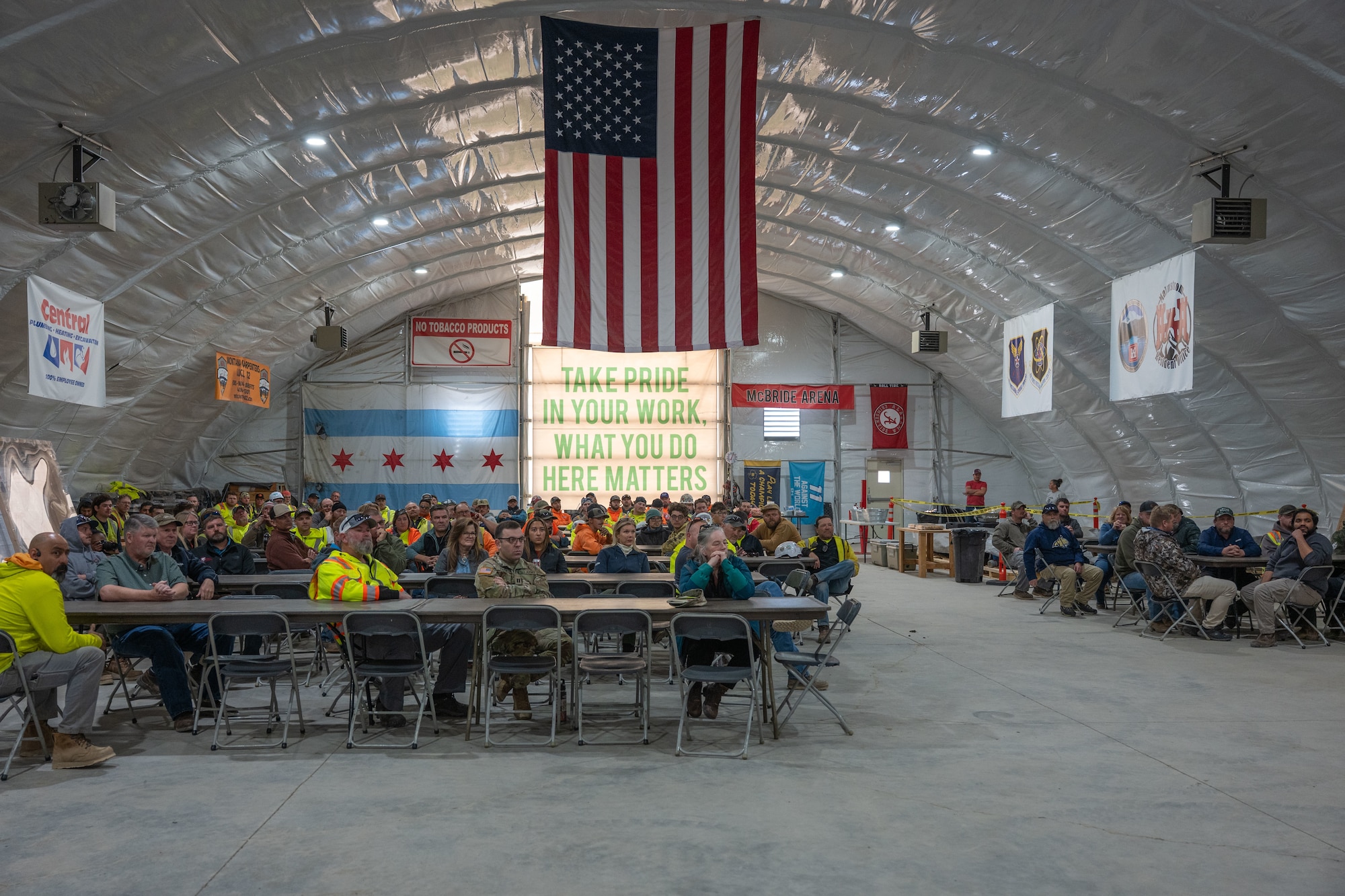 Workers sit in a room while looking at a speaker.