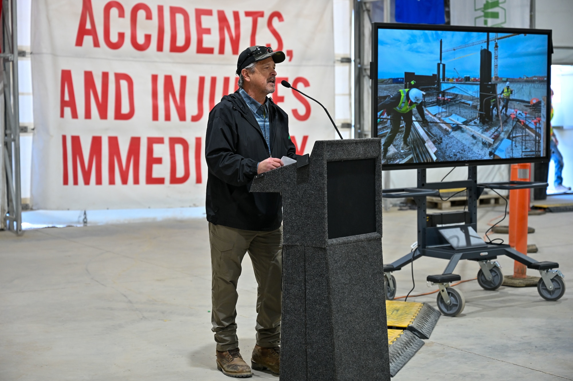 A man speaks behind a podium.