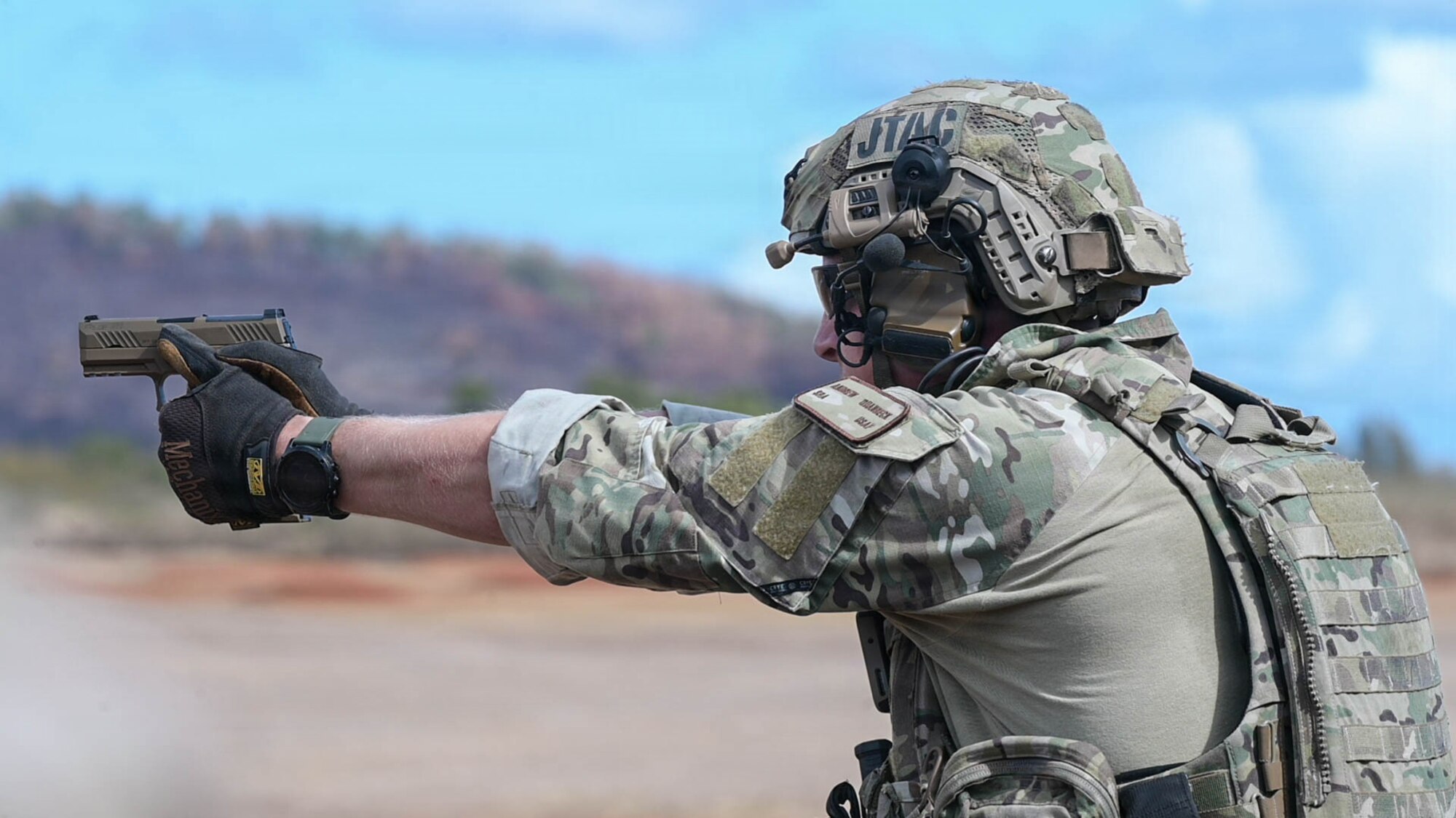 Airman points a pistol at a target.
