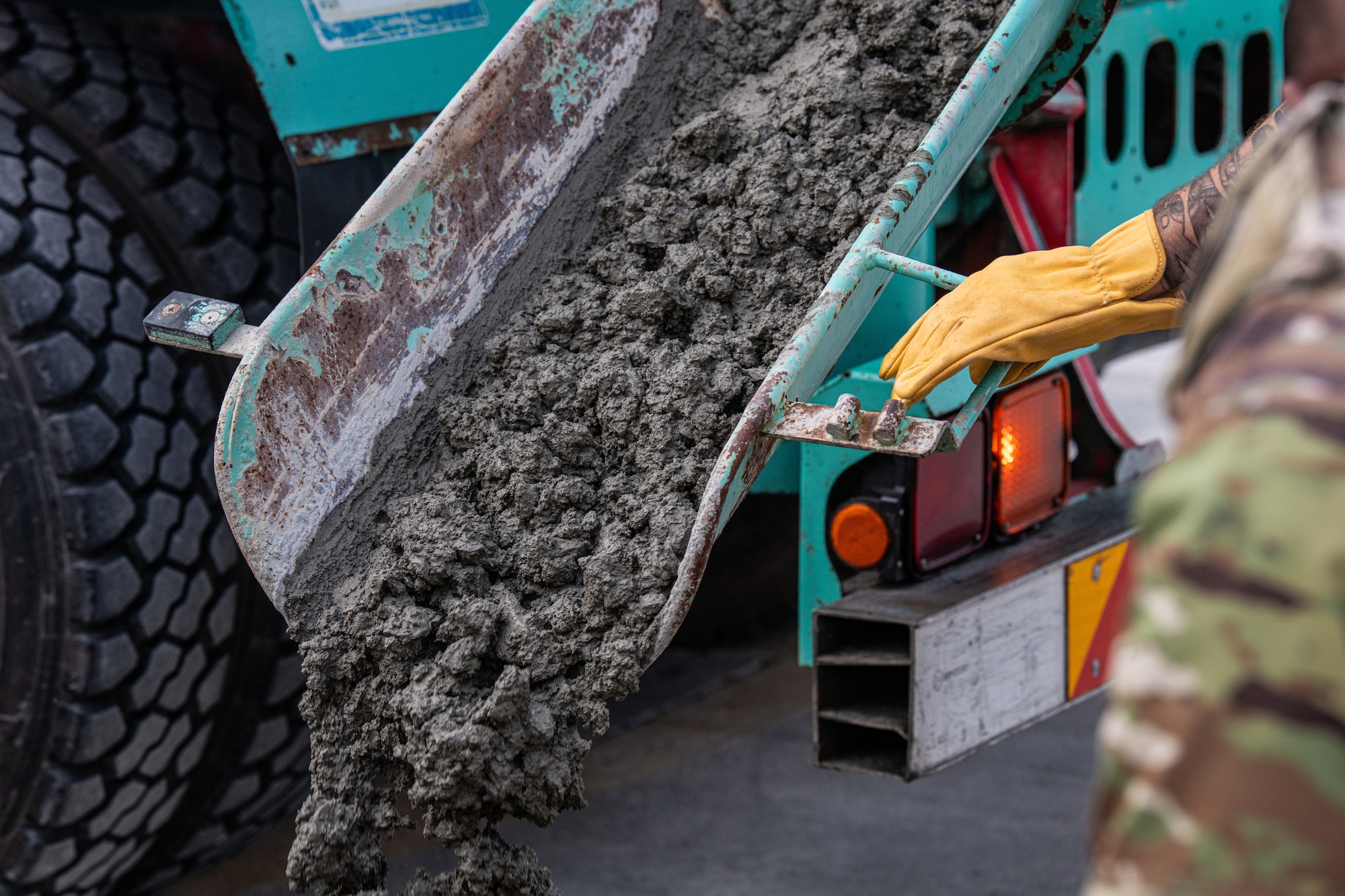 A concrete truck delivers wet concrete to Airmen assigned to the 18th Civil Engineer Squadron during a full-depth pavement repair on Kadena Air Base, Nov. 14, 2025. Precise scheduling ensured each truck arrived within strict time limits to maintain concrete quality. (U.S. Air Force photo by Airman 1st Class Francisco Huerta)