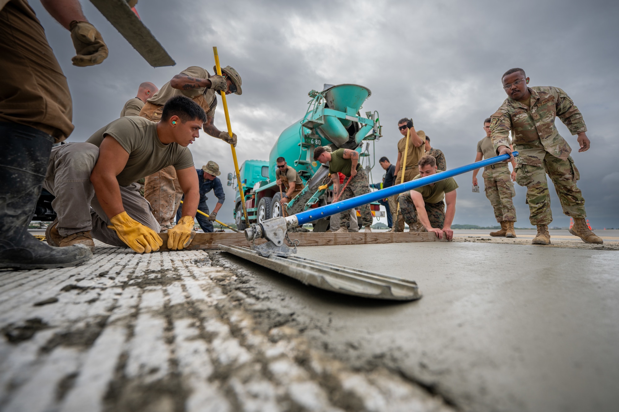 U.S. military service members assigned to Kadena Air Base lay concrete during a full-depth pavement repair at Kadena Air Base, Japan, Nov. 14, 2025. Concrete meets the structural standards for heavy airframes. (U.S. Air Force photo by Airman 1st Class Francisco Huerta)