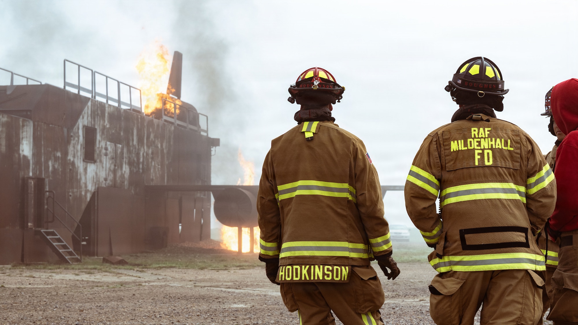 U.S. Air Force firefighters assigned to the 100th Civil Engineer Squadron assess a simulated aircraft fire during training at RAF Mildenhall, England, Sept. 29, 2025.