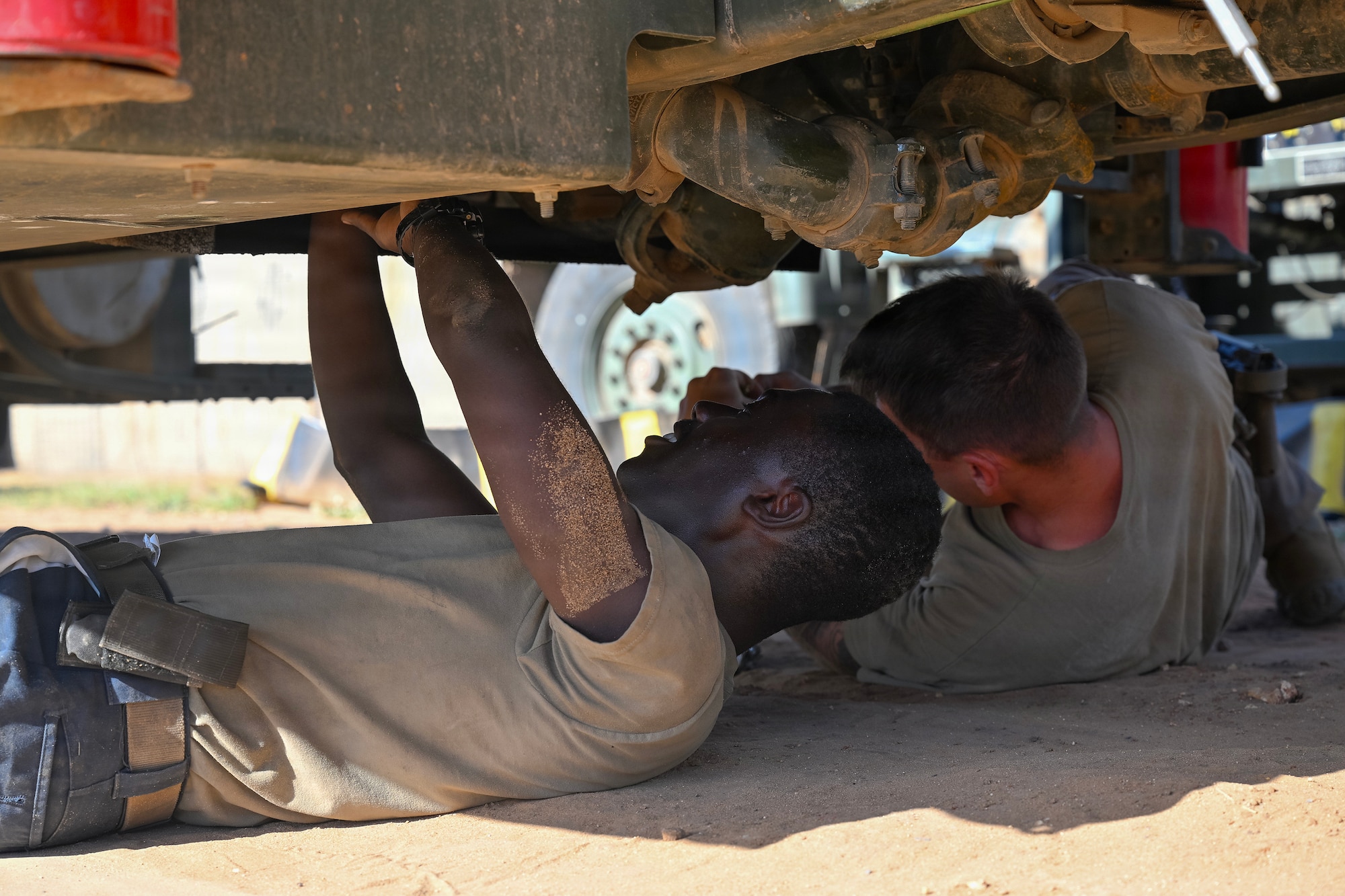 U.S. Air Force Senior Airman Jacob Rosales and Airman 1st Class Kwaku Owusu, 475th Expeditionary Air Base Squadron Vehicle Maintenance section, work beneath an R-11 fuel truck at Camp Simba, Kenya, Oct. 20, 2025.