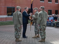 Group of people standing in circle as one passes flag to another