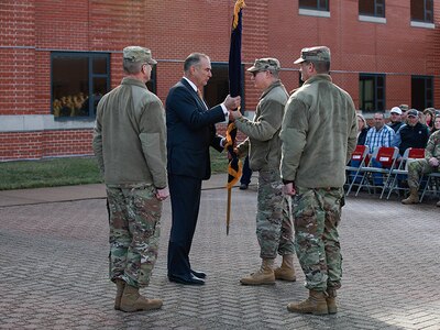 Group of people standing in circle as one passes flag to another
