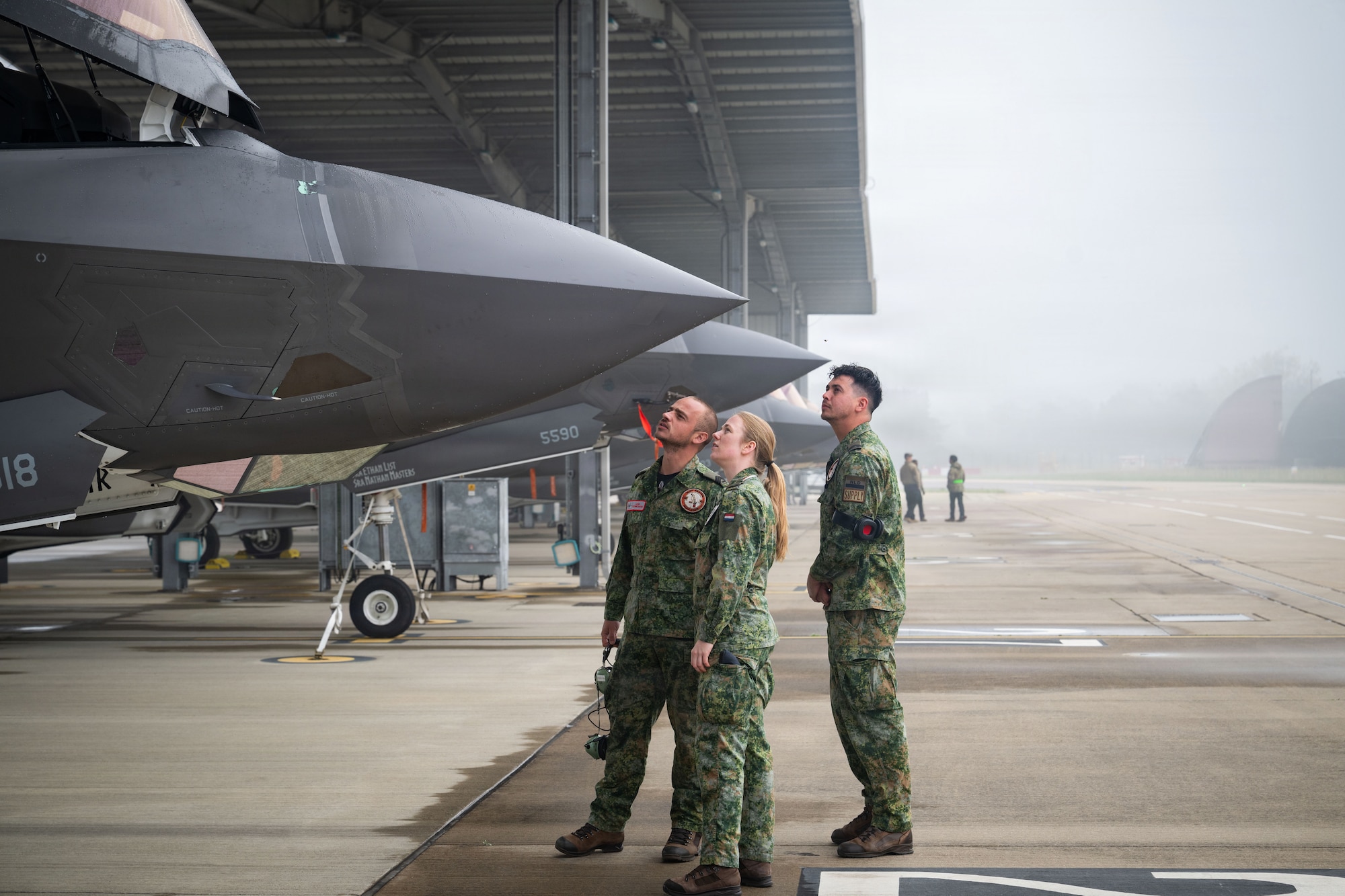 Photo of Royal Netherlands Air Force and RAF Lakenheath members looking at F-35A Lightning II aircraft.