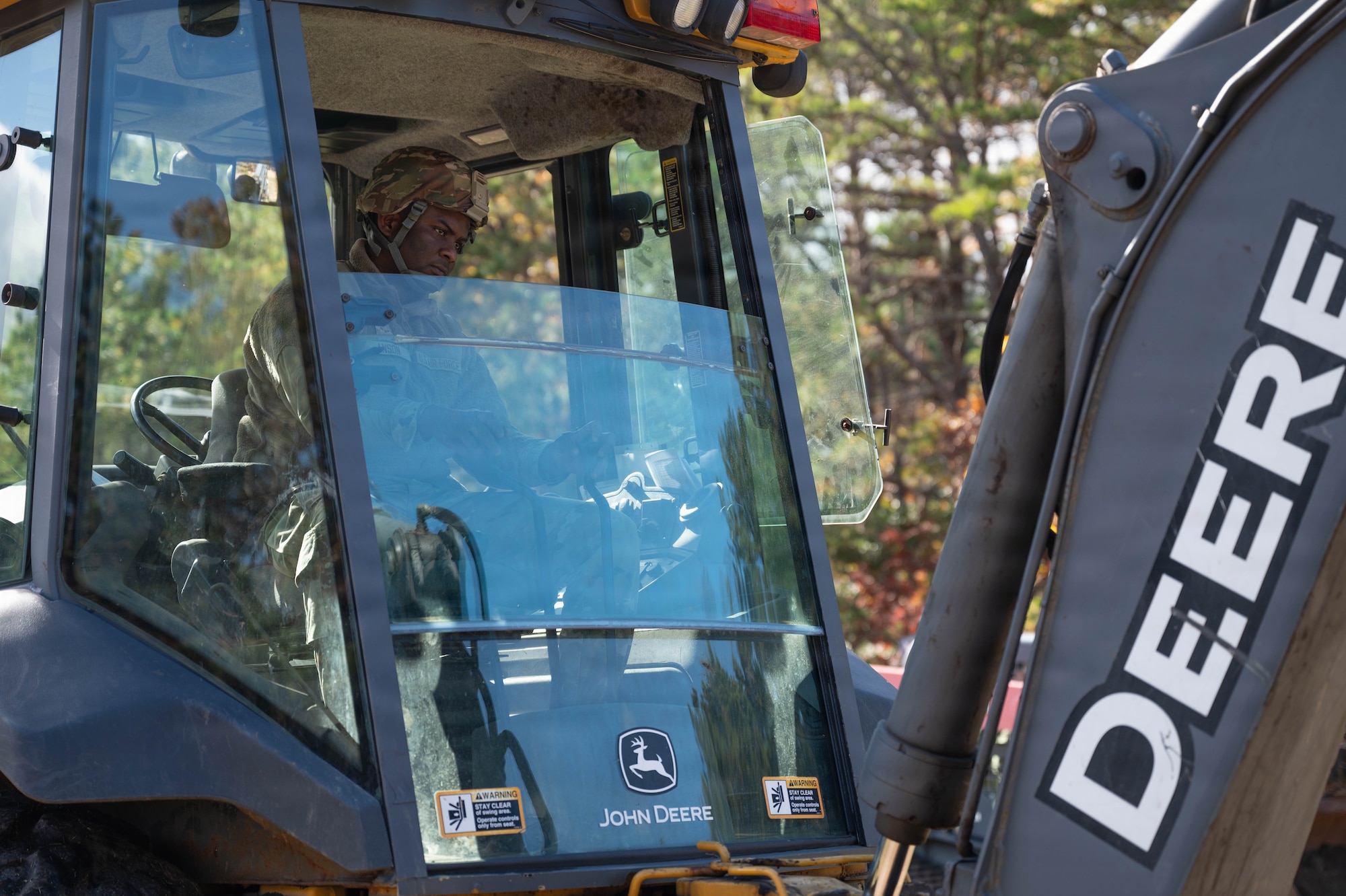 Photo of an Airman operating a backhoe.