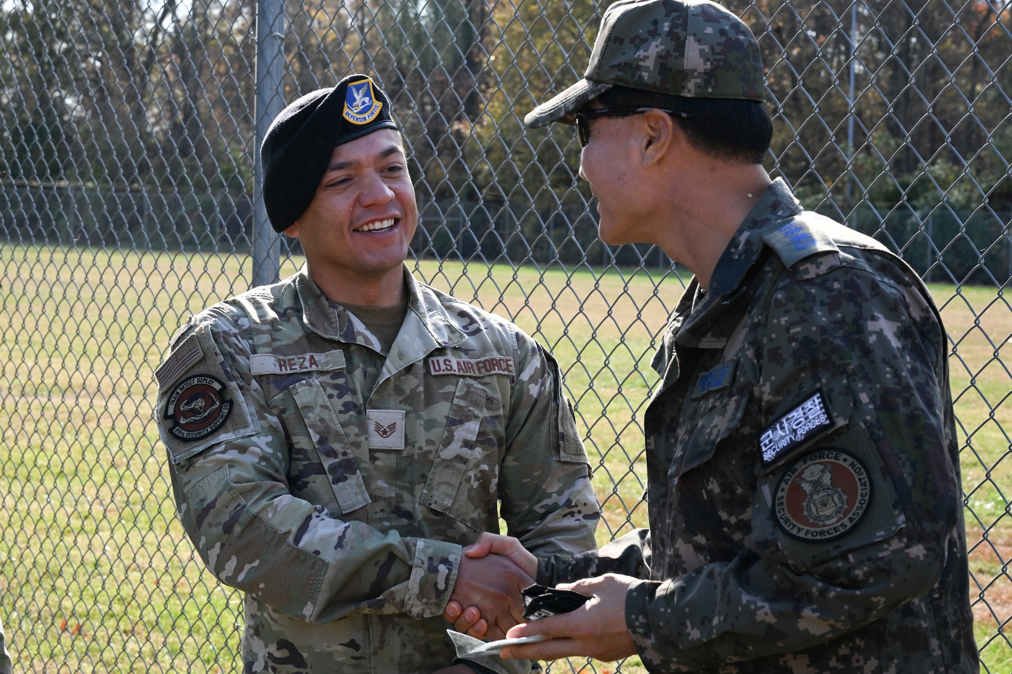 Republic of Korea Air Force Col. Jongsung Woo, Air Force Military Police Agency commander, right, gives a patch to U.S. Air Force Staff. Sgt. Alex Reza.