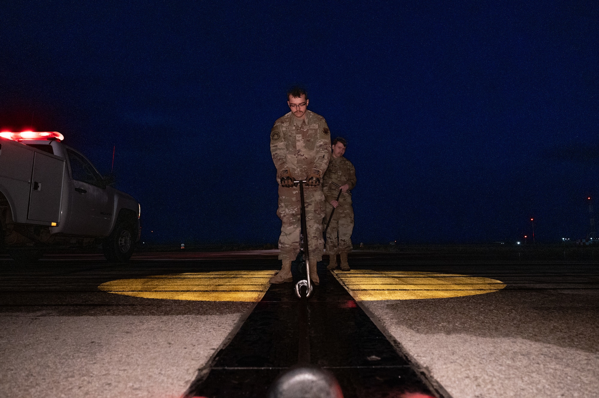 service members fix arresting cable on flightline