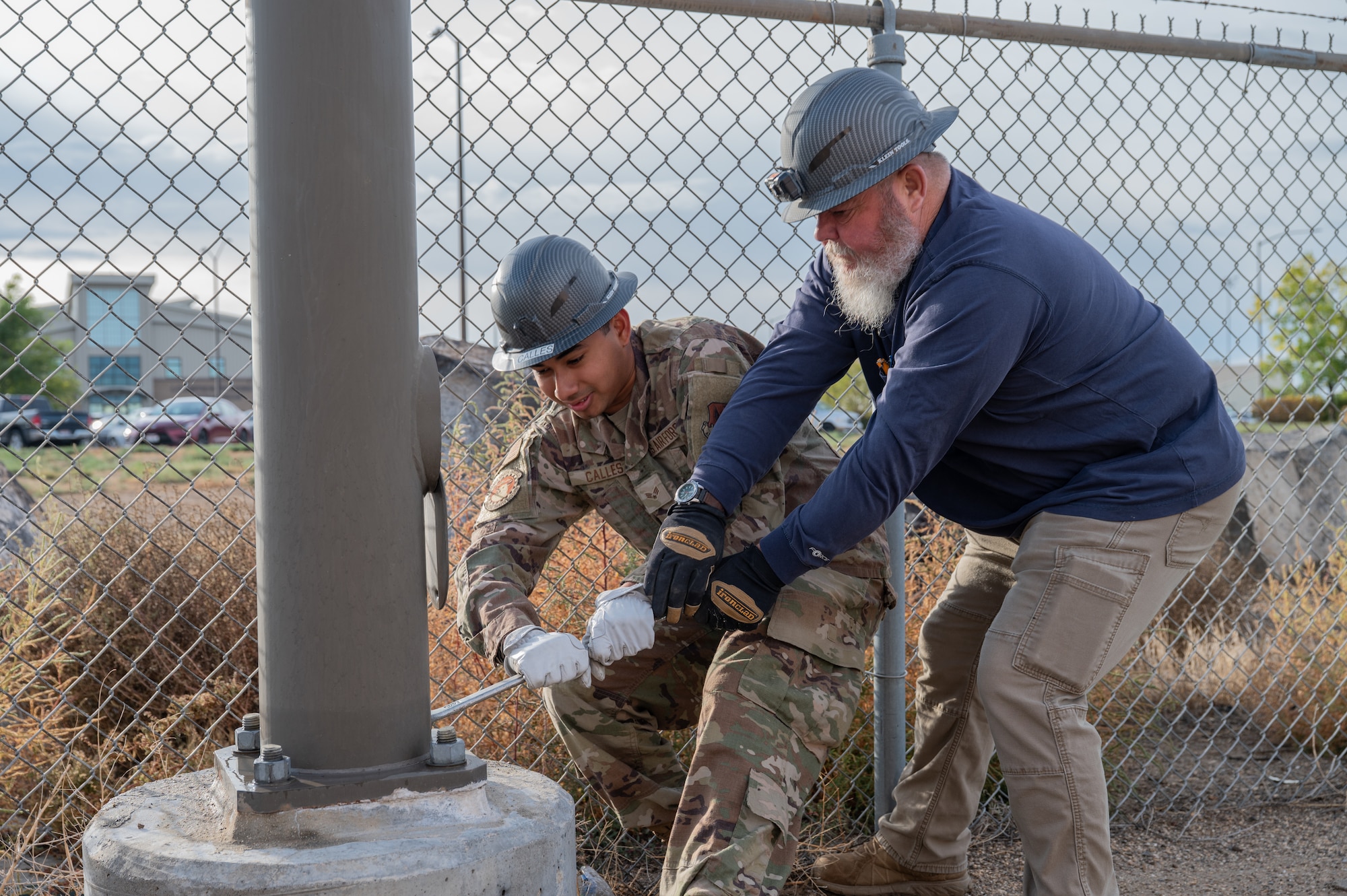 Service members remove street light bolts