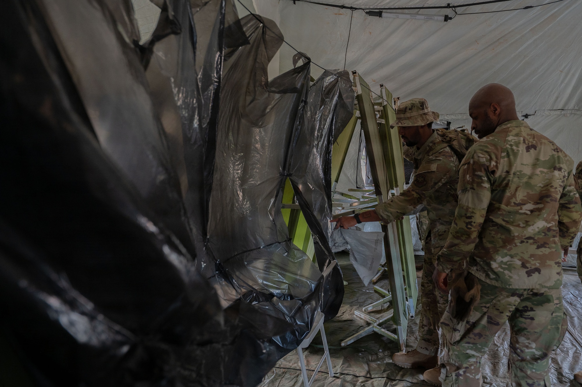 U.S. Airmen assigned to the 21st Combat Air Base Squadron set up an expeditionary Mortuary Affairs Center during Joint Pacific Multinational Readiness Center 26-01 at Schofield Barracks, Hawaii, Nov. 6, 2025. The training prepared Airmen to execute the entire mortuary process in austere environments while operating as part of the Joint and multinational force in the Indo-Pacific. (U.S. Air Force photo by Senior Airman Alondra Cristobal Hernandez)
