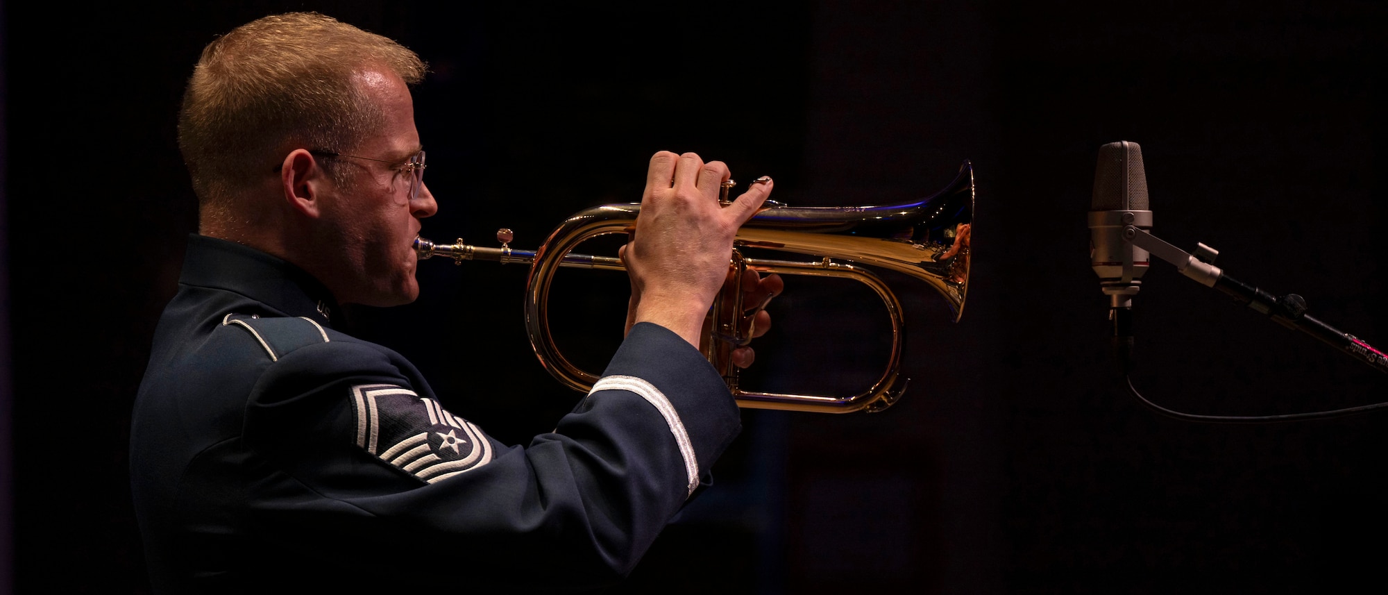 U.S. Air Force Senior Master Sgt. Lucas A. Brandon, a trumpet player for the U.S. Air Force Band’s Airmen of Note, plays the flugelhorn during their 75th anniversary concert in Alexandria, Va., Sept. 26, 2025. Band members frequently switched instruments to maintain maximum capabilities for the small team, embracing the Mission Ready Airmen concept. Trumpet players in jazz groups typically double on flugelhorn for a smoother sound, while saxophonists may play up to seven instruments within the woodwind family. (U.S. Air Force photo by Staff Sgt. Jordan Powell)