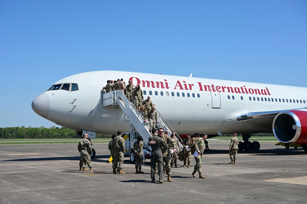 A group of people deboard a plane.