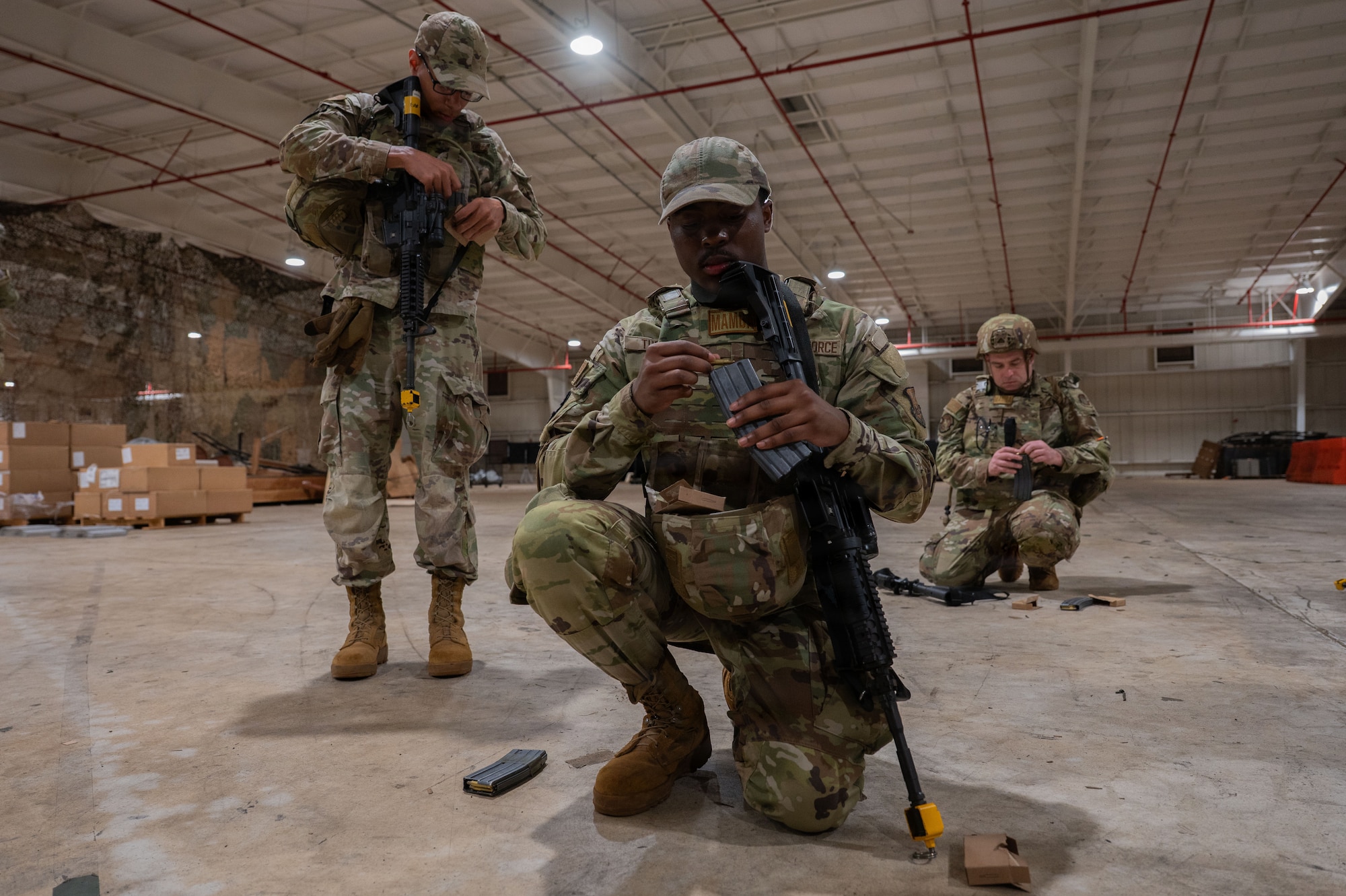 U.S. Airmen assigned to the 21st Combat Air Base Squadron load ammo into magazines as part of Close Quarters Battle training during Joint Pacific Multinational Readiness Center 26-01 at Schofield Barracks, Hawaii, Nov. 6, 2025. These training events prepare the 21st CABS to operate in contested environments, increasing combat survivability and lethality, and enhancing readiness for worldwide missions. (U.S. Air Force photo by Senior Airman Alondra Cristobal Hernandez)