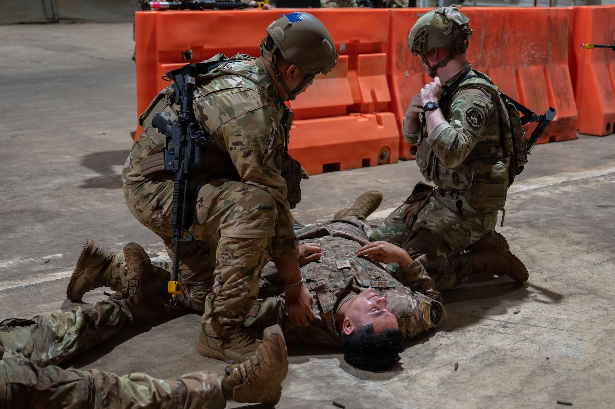 U.S. Airmen assigned to the 21st Combat Air Base Squadron provide medical assistance as part of Close Quarters Battle training during Joint Pacific Multinational Readiness Center 26-01 at Schofield Barracks, Hawaii, Nov. 9, 2025. JPMRC 26-01 is designed to test readiness through intricate exercises, improve rapid deployment of forces and exercise mission command. (U.S. Air Force photo by Senior Airman Alondra Cristobal Hernandez)