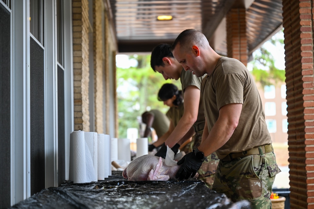 Service members are cleaning turkeys.