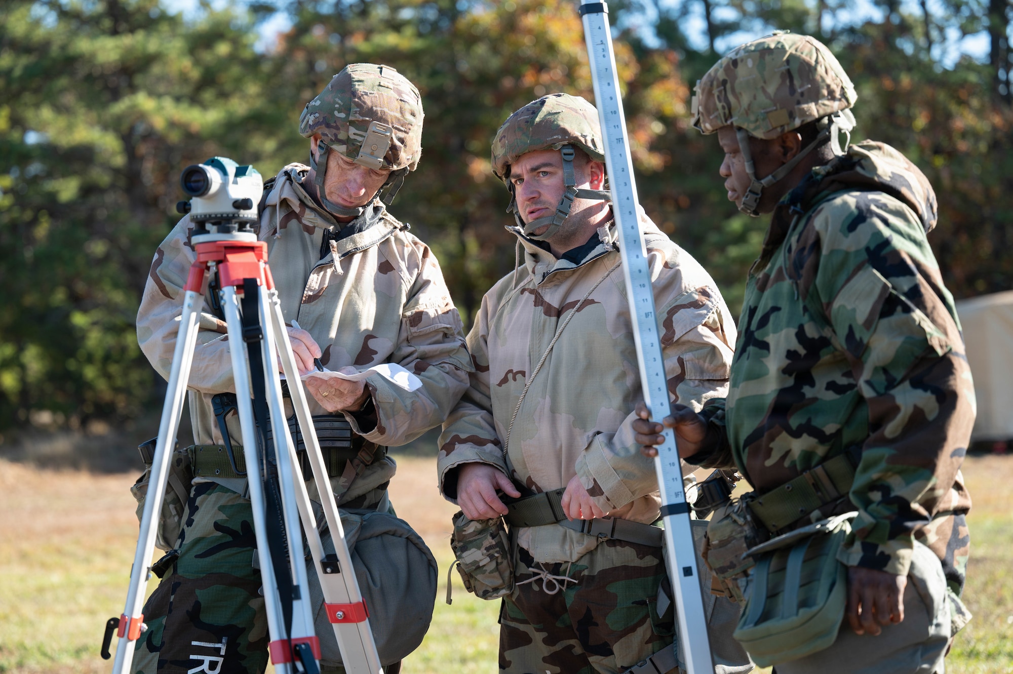 Photo of three Airmen performing an engineering survey.