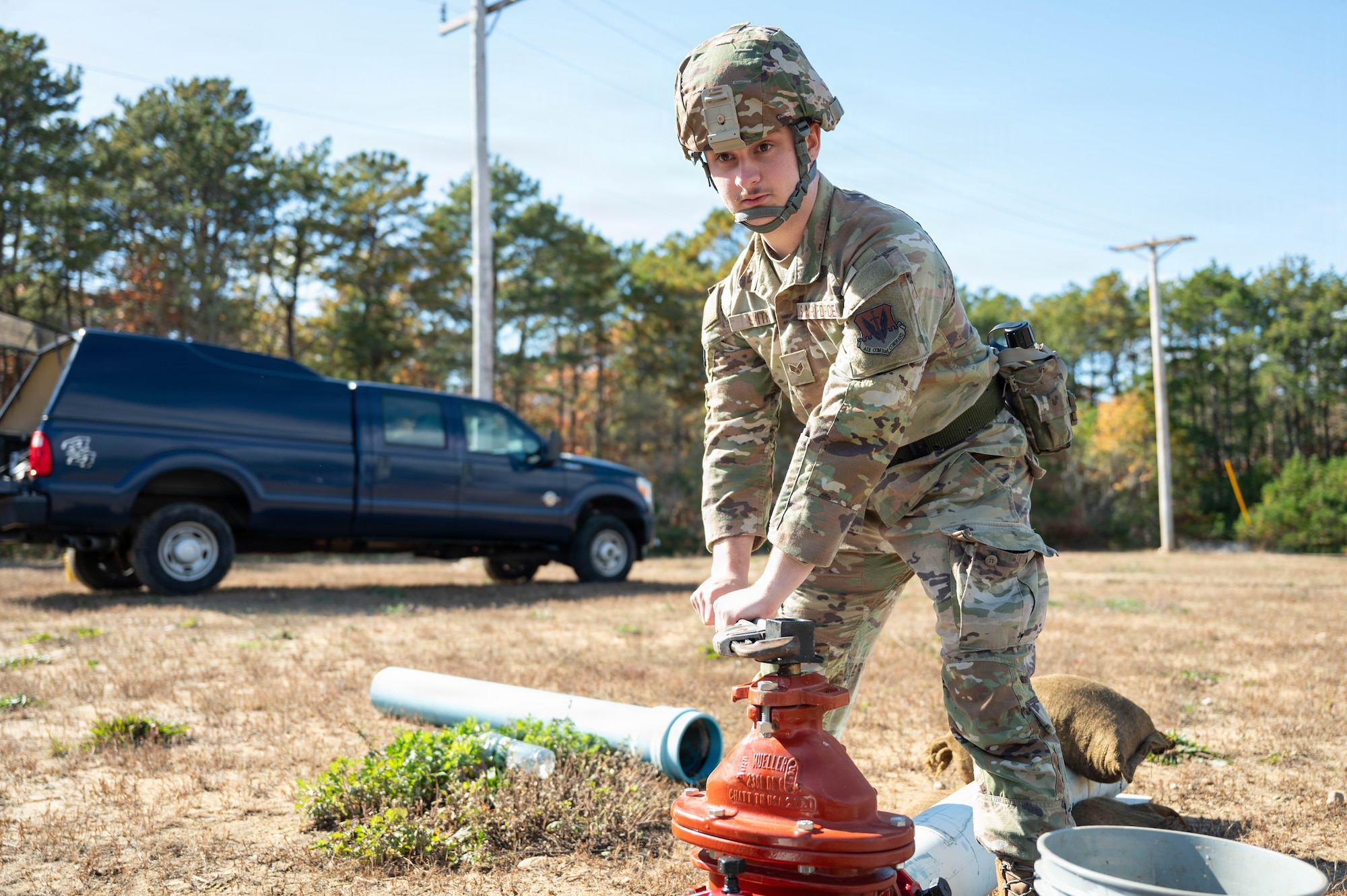 Photo of an Airman tightening a valve on a fire hydrant.