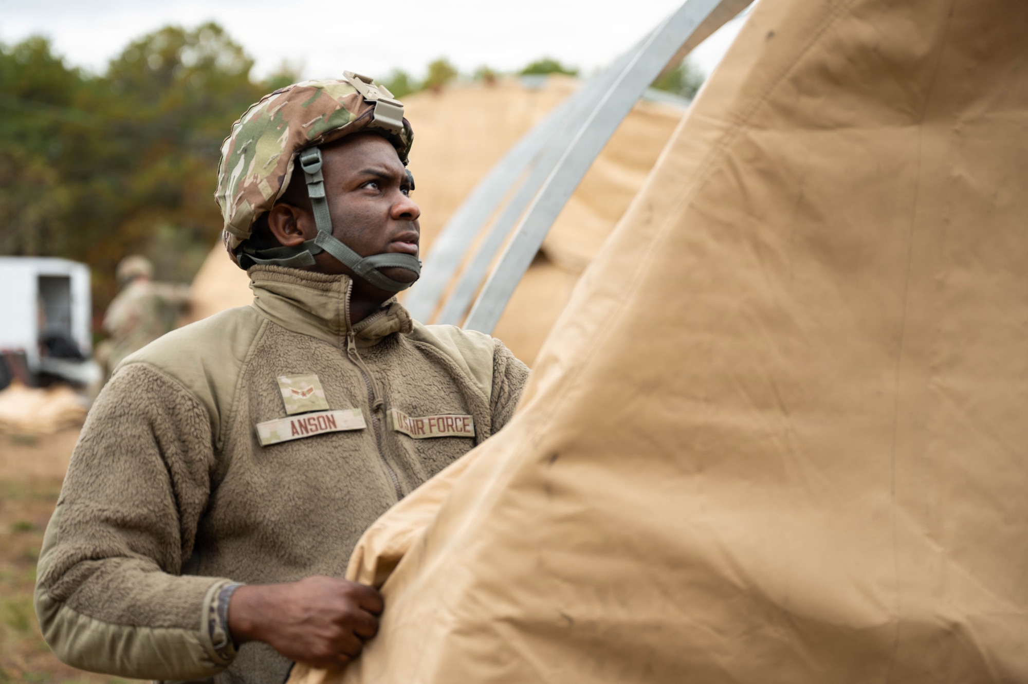 Photo of an Airman building a tent.