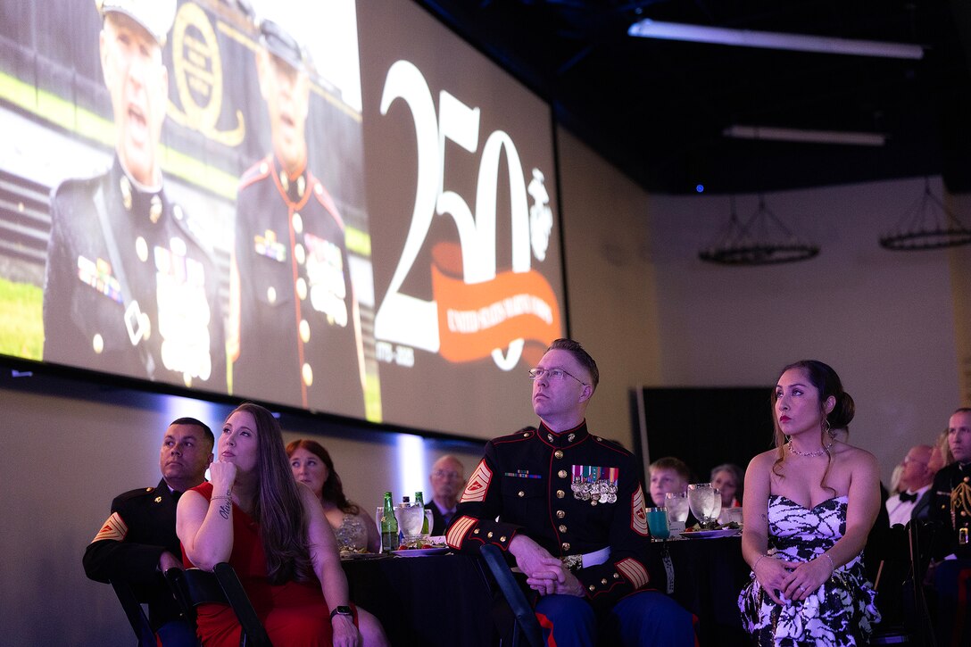 U.S. service members, civilians, contractors and veterans gather with community leaders to watch the 250th Marine Corps birthday message during the ceremony hosted Nov. 21 by Blount Island Command at Deerwood Castle in Jacksonville, Florida. (Official Marine Corps photo by Dustin Senger)