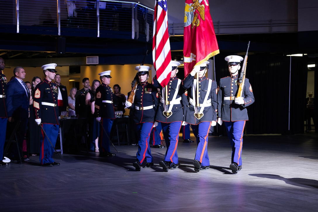 U.S. Marines march the colors during the 250th Marine Corps birthday ball ceremony hosted Nov. 21 by Blount Island Command at Deerwood Castle in Jacksonville, Florida. The evening honored generations of service shared between Marine Corps Support Facility Blount Island and the surrounding Jacksonville community. (Official Marine Corps photo by Dustin Senger)
