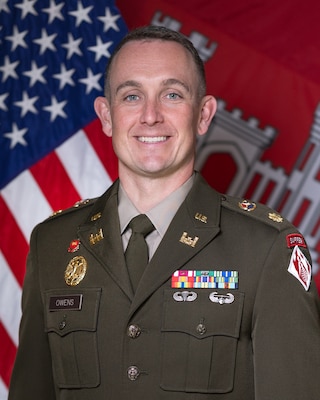 Portrait of Army Major in Class A uniform with the US and US Army Corps of Engineers flags in the background