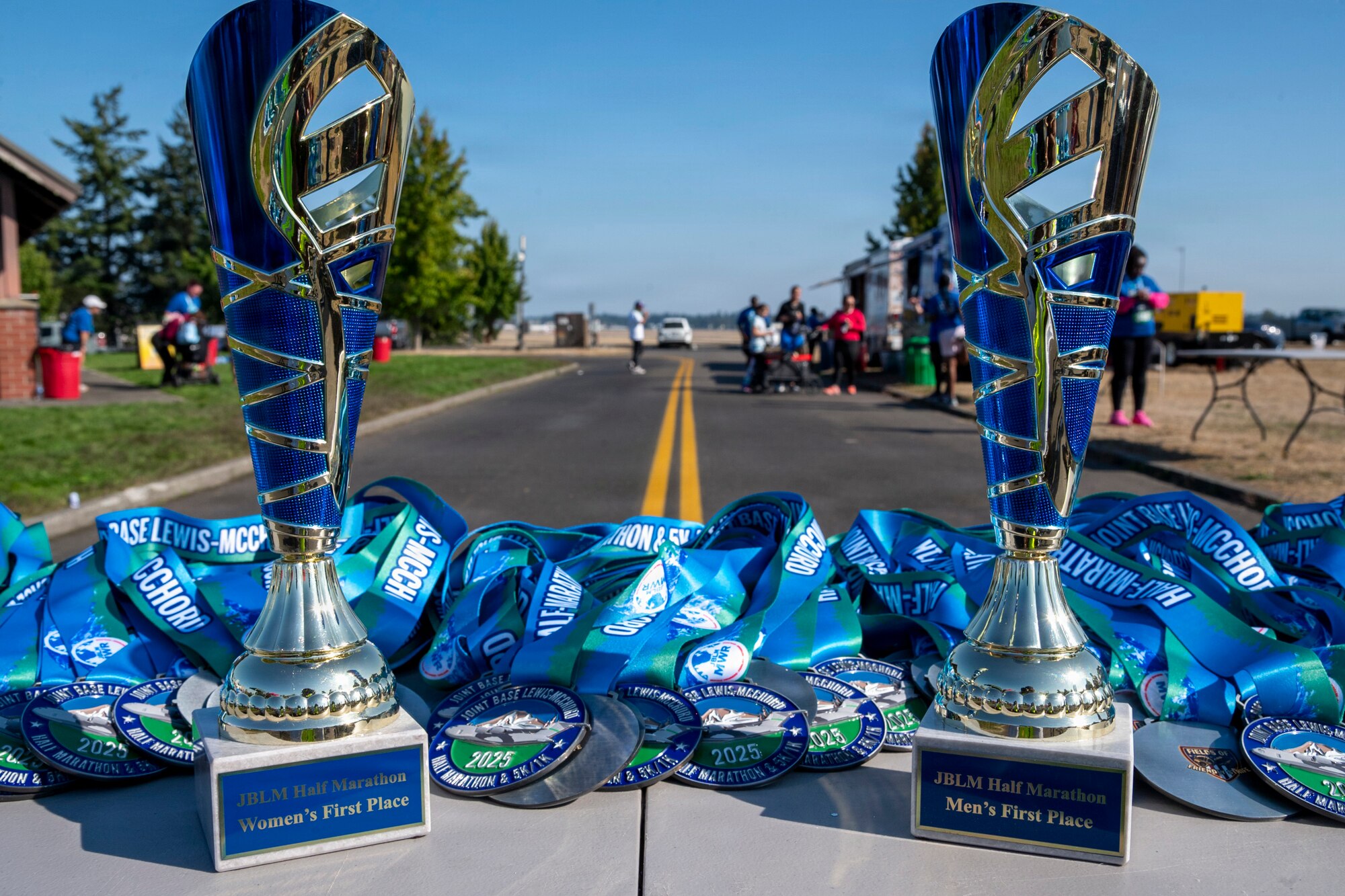 a fold out table with two trophies and several medallions on it and a street in the background