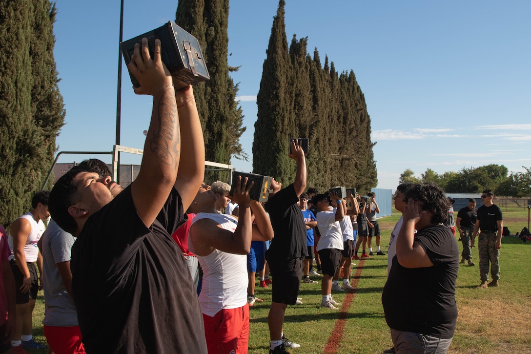 U.S. Marines with Recruiting Sub-Station Fresno, Recruiting Station Sacramento, host a modified combat fitness test for varsity football players at Firebaugh High School in Firebaugh, California, Sept. 23, 2025. The CFT evaluates a Marine's combat readiness with three components: an 880-yard Movement to Contact sprint, a 2-minute Ammunition Can Lift of a 30-pound can overhead, and a timed Maneuver Under Fire course with obstacles including low crawls, sprints, and a simulated grenade toss. This test was modified to uphold the integrity and safety of Marine Corps standards and the individuals who partook while on the high school campus. (U.S. Marine Corps photo by Staff Sgt. Ryan Harvey)