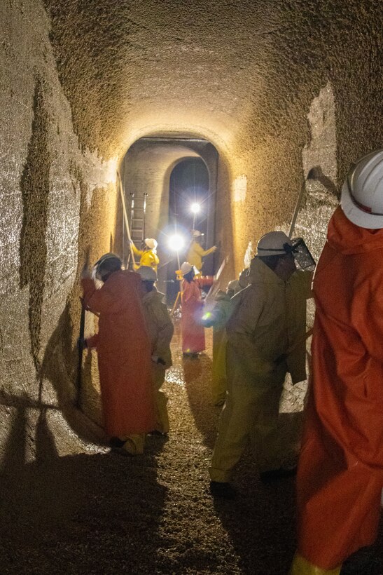 Seattle District volunteers scrape barnacles from the walls of one of the culverts in the large lock at the Hiram M. Chittenden Locks to prevent injury to migrating fish, including salmon. The large lock has two culverts, each about 800 feet long, 8 feet wide and 14 feet tall.