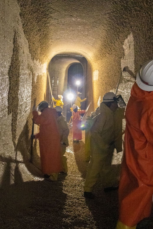 Seattle District volunteers scrape barnacles from the walls of one of the culverts in the large lock at the Hiram M. Chittenden Locks to prevent injury to migrating fish, including salmon. The large lock has two culverts, each about 800 feet long, 8 feet wide and 14 feet tall.