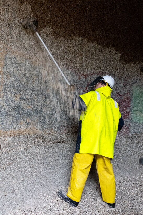 A Seattle District teammate scrapes barnacles from one of the large lock culverts at at the Hiram M. Chittenden Locks, an annual event which prevents injury to migrating fish.