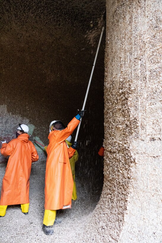 Seattle District teammates scrape barnacles from one of the large lock culverts at at the Hiram M. Chittenden Locks, an annual event which prevents injury to migrating fish.