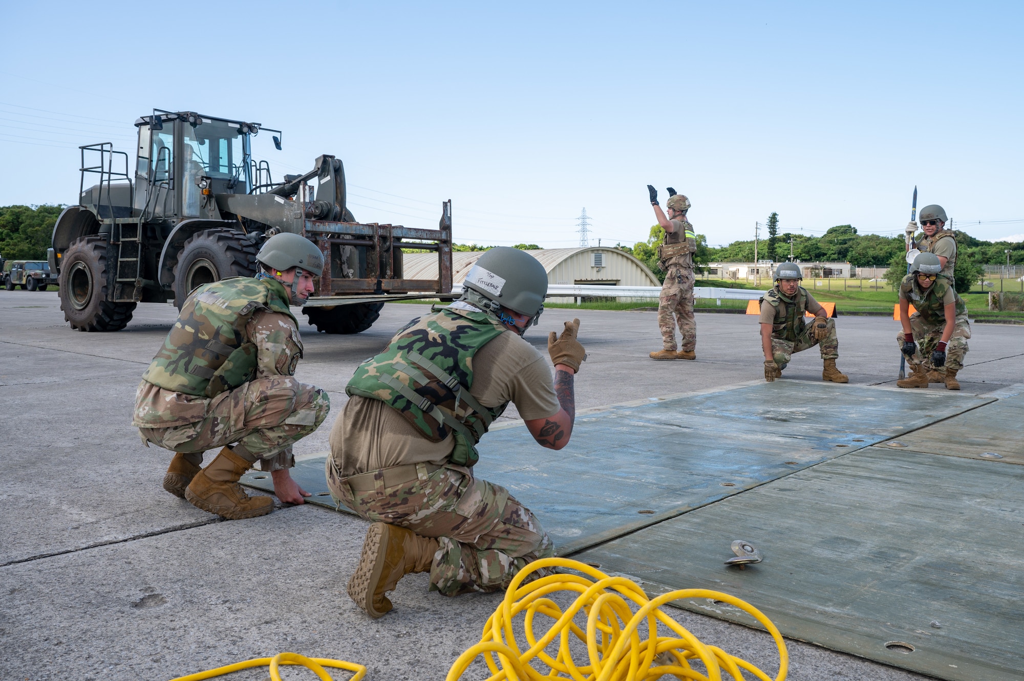 U.S. Air Force Airmen from the 18th Civil Engineer Squadron conduct rapid airfield damage repair after a simulated airstrike during base-wide readiness exercise BH 26-1 at Kadena Air Base, Japan, Nov. 6, 2025. The scenario allowed Airmen to refine the coordination and technical skills needed to maintain air operations in contested environments.  (U.S. Air Force photo by Airman 1st Class Francisco Huerta)